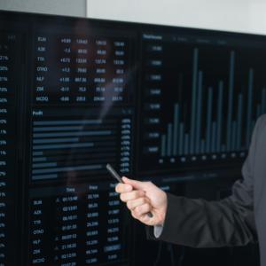 Foto de braço apontando um quadro com textos e gráficos