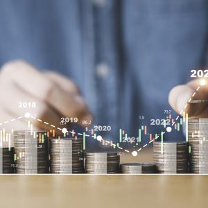 Homem manipulando moedas formando um gráfico com as mesmas.